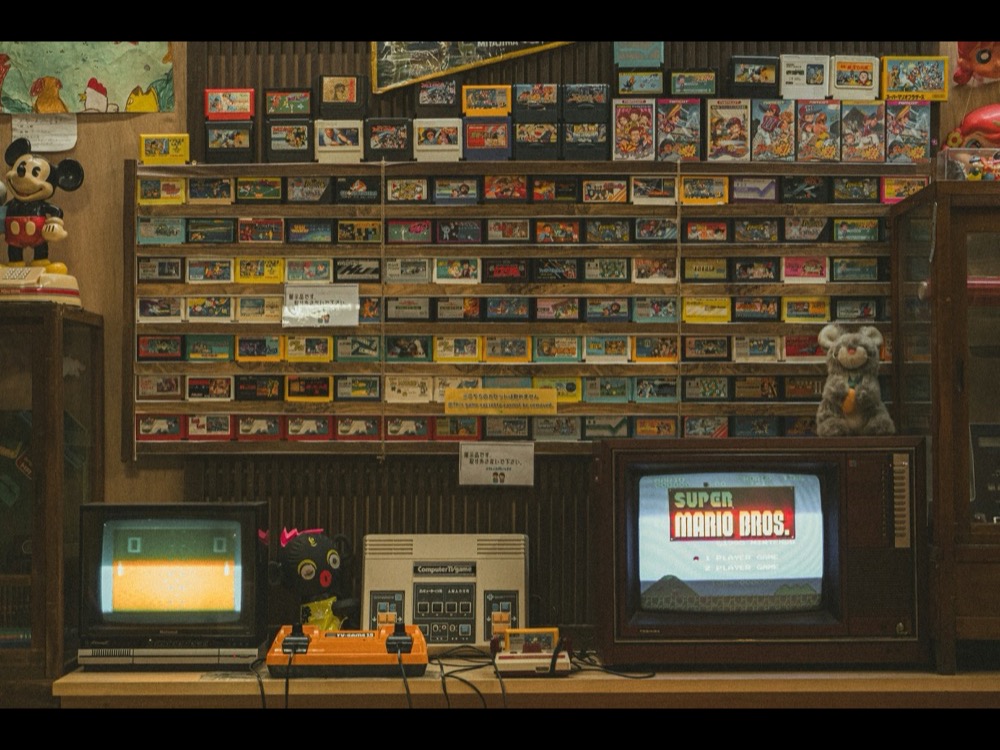 Stěna plná herních kazet a retro konzolí
